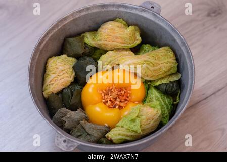 Peperoni dolci ripieni fatti in casa e involtini di cavolo in un calderone, pronti per la preparazione Foto Stock