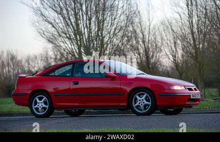 Stony Stratford, Regno Unito, 1 gennaio 2024. 1995 auto Vauxhall Calibra rossa che arriva a Stony Stratford per l'annuale veicolo d'epoca e classico fe il giorno di Capodanno Foto Stock