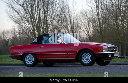 Stony Stratford, Regno Unito 1 gennaio 2024,1980 Mercedes Benz rossa 450 in arrivo a Stony Stratford per l'annuale veicolo d'epoca e classico fe il giorno di Capodanno Foto Stock