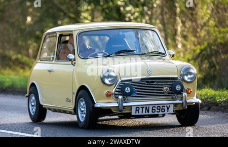 Stony Stratford, Regno Unito, 1 gennaio 2024. 1982 auto gialla Austin Mini 1000 City che arriva a Stony Stratford per l'annuale Capodanno in stile vintage e classico Foto Stock