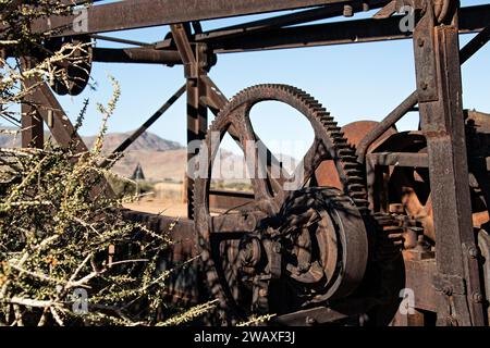 Ruote dentate rugginite di una vecchia macchina trebbiante nel deserto di Betta in Namibia. Foto Stock