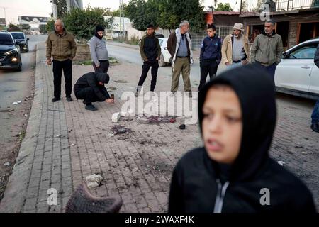 Jenin. 7 gennaio 2024. La gente controlla il luogo di uno sciopero nella città di Jenin, 7 gennaio 2024. Sette palestinesi sono stati uccisi domenica mattina da un drone israeliano nella Cisgiordania occupata, mentre un agente di polizia israeliano è stato ucciso quando il suo veicolo ha colpito una bomba a bordo strada, hanno dichiarato fonti israeliane e palestinesi domenica. Il Ministero della salute palestinese ha dichiarato in una dichiarazione che le sette vittime erano civili, tra cui quattro fratelli del villaggio di Muthalath ash-Shuhada, nella zona di Jenin, nella Cisgiordania settentrionale. Credito: Ayman Nobani/Xinhua/Alamy Live News Foto Stock