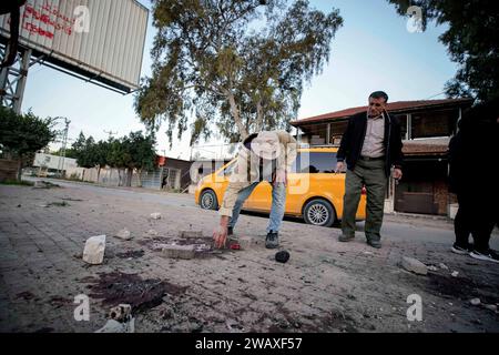 Jenin. 7 gennaio 2024. La gente controlla il luogo di uno sciopero nella città di Jenin, 7 gennaio 2024. Sette palestinesi sono stati uccisi domenica mattina da un drone israeliano nella Cisgiordania occupata, mentre un agente di polizia israeliano è stato ucciso quando il suo veicolo ha colpito una bomba a bordo strada, hanno dichiarato fonti israeliane e palestinesi domenica. Il Ministero della salute palestinese ha dichiarato in una dichiarazione che le sette vittime erano civili, tra cui quattro fratelli del villaggio di Muthalath ash-Shuhada, nella zona di Jenin, nella Cisgiordania settentrionale. Credito: Ayman Nobani/Xinhua/Alamy Live News Foto Stock