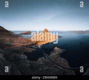 Splendida vista aerea dell'alta montagna Kirkjufell in Islanda, sulla penisola di Snaefellsnes. Alba al tramonto con luce arancione tenue. Islanda occidentale. Foto Stock