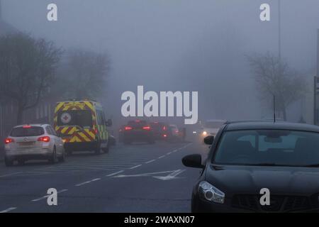 Moira, County Down, Irlanda del Nord, Regno Unito. 7 gennaio 2024. Clima del Regno Unito - una giornata fredda e grigia d'inverno con nebbia che si protrarrà tutto il giorno nel villaggio di County Down. Strada principale del villaggio alle 13:00. Credito: CAZIMB/Alamy Live News. Foto Stock