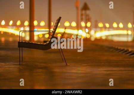 Budapest, Ungheria - 29 dicembre 2023: Fiume Danubio allagato. Panchina vicino all'edificio del parlamento. Ponte Margit sullo sfondo. Foto Stock