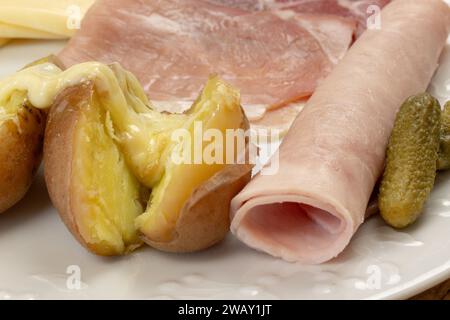 formaggio raclette fuso spalmato su una patata Foto Stock
