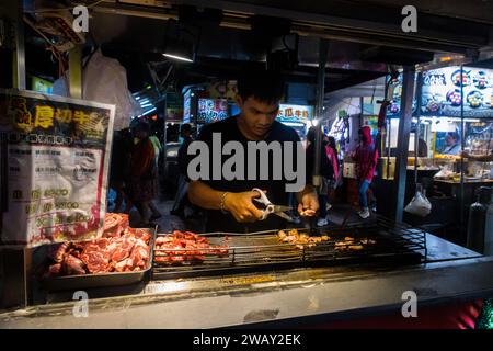 Taipei, Taiwan - 9 ottobre 2023: Venditori ambulanti che vendono cucine taiwanesi e cibo di mare al mercato notturno di Raohe a Taiwan Foto Stock