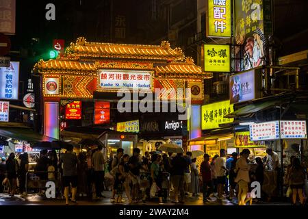 Taipei, Taiwan - 9 ottobre 2023: Gruppo di turisti e visitatori fuori dal mercato notturno di via di Raohe a Taiwan Foto Stock