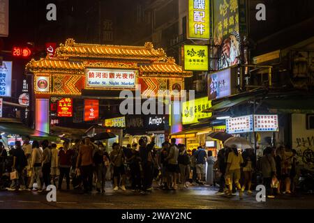 Taipei, Taiwan - 9 ottobre 2023: Gruppo di turisti e visitatori fuori dal mercato notturno di via di Raohe a Taiwan Foto Stock