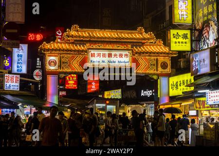 Taipei, Taiwan - 9 ottobre 2023: Gruppo di turisti e visitatori fuori dal mercato notturno di via di Raohe a Taiwan Foto Stock