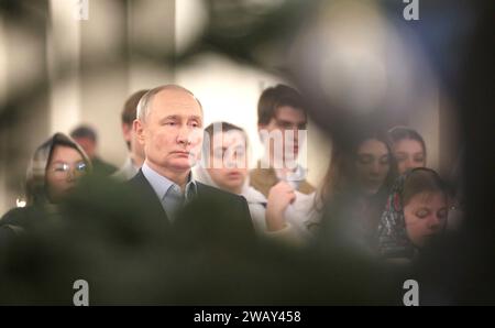 Novo-Ogaryovo, Russia. 7 gennaio 2024. Il presidente russo Vladimir Putin partecipa a un servizio natalizio ortodosso presso la Chiesa dell'icona del Salvatore non fatto a mano presso la residenza presidenziale ufficiale di Novo-Ogaryovo, il 7 gennaio 2024 a Novo-Ogaryovo, Oblast' di Mosca, Russia. Putin ha ospitato famiglie di soldati uccisi nella guerra Ucraina per la celebrazione. Crediti: Gavriil Grigorov/Cremlino Pool/Alamy Live News Foto Stock