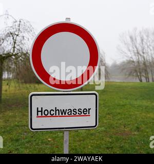 Il sentiero è stato chiuso a causa delle inondazioni sulle rive del fiume Elba a Magdeburgo in Germania nel gennaio 2024. Traduzione sul cartello: Acqua alta Foto Stock