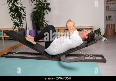 Uomo rilassato che impara le pose di yoga con l'insegnante Foto Stock