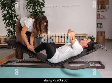 Uomo rilassato che impara le pose di yoga con l'insegnante Foto Stock