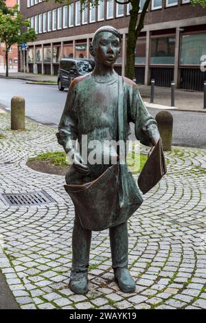 Scultura in bronzo di un ragazzo di giornale a Kiel, Schleswig-Holstein, Germania. Foto Stock