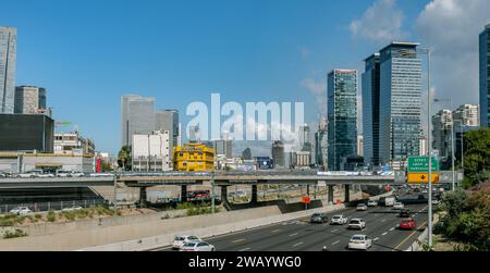 Tel Aviv Israele. 15 novembre 2023. Auto sulle rotte Ayalon, Derech hashalom. Ponte, treno ed edifici moderni nell'area degli affari Foto Stock