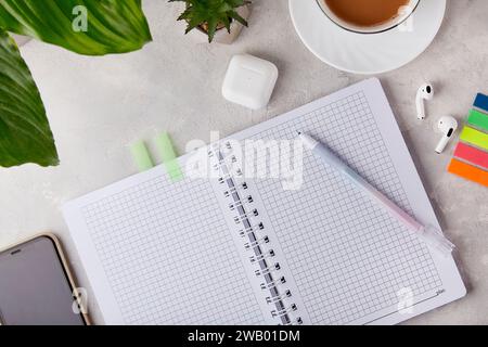 Productivity Zen - Vista dall'alto di un notebook vuoto e di una penna - auricolari audio, telefono mock-up e tazza di caffè Foto Stock