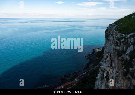 Vista dall'alto su una scogliera ripida e sul mare blu a Cefalù, Sicilia, Italia Foto Stock