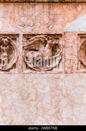 Dettaglio dei rilievi in marmo rosa veronese, nella facciata del Battistero di Parma, piazza del Duomo nel centro di Parma, Emilia Romagna, Italia Foto Stock