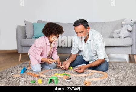 Nonno anziano e nipotino che giocano al coperto Foto Stock