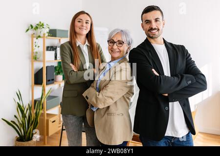 Ritratto di tre uomini d'affari che sorridono alla fotocamera in ufficio Foto Stock