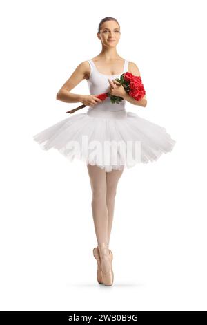 Ritratto a tutta lunghezza di una ballerina con un abito bianco che regge un mazzo di rose rosse isolate su sfondo bianco Foto Stock