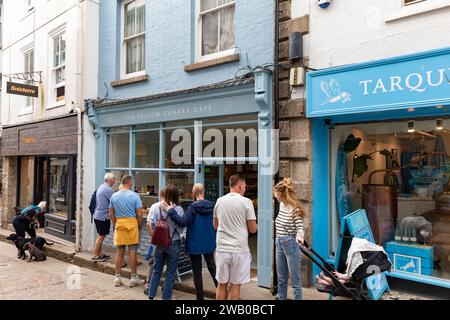 St Ives Cornwall Inghilterra, strada principale nel centro città e i clienti fanno la fila fuori dalla caffetteria gialla canary Cafe, Regno Unito, 2023 Foto Stock