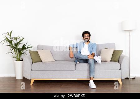 Un uomo indiano positivo e figo che si gode il tempo a casa Foto Stock