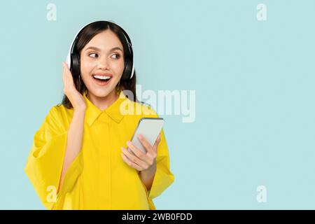 Gioiosa giovane donna ispanica con cuffie touch per smartphone Foto Stock