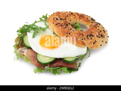 Bagel saporito con prosciutto stagionato, uova, cetrioli e insalata mescolati isolati su bianco Foto Stock