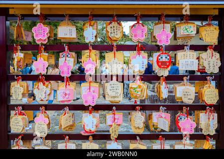 Kyoto, Giappone - 6 aprile 2023: Splendida fioritura dei ciliegi "Ema" - piccole targhe di legno con desideri di preghiere scritte appese al tempio Ninnaji Foto Stock