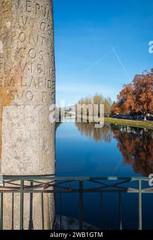 Messa a fuoco selettiva. Pietra miliare con iscrizione latina all'ingresso del ponte sul Tamega a Chaves, Portogallo. Foto Stock