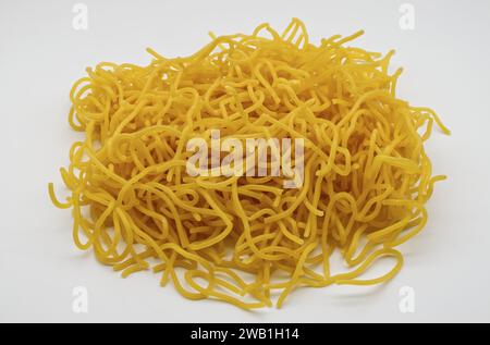 Tonnarelli isolato su sfondo bianco. Pasta italiana fresca all'uovo trafilata al bronzo. Tonnarelli è una varietà di pasta simile agli spaghetti alla chitarra. Foto Stock