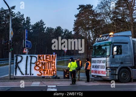 Cottbus, Germania. 8 gennaio 2024. Le aziende di trasporto utilizzano i loro veicoli per sostenere gli agricoltori che bloccano una strada di accesso all'autostrada A15. In risposta ai piani di austerità del governo federale, l'associazione degli agricoltori ha chiesto una settimana di azione con raduni e raduni a partire dall'8 gennaio. Il 15 gennaio si concluderà con un'importante manifestazione nella capitale. Crediti: Frank Hammerschmidt/dpa/Alamy Live News Foto Stock