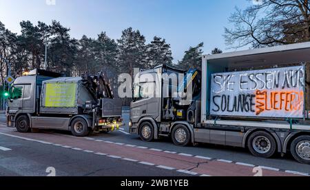 Cottbus, Germania. 8 gennaio 2024. Le aziende di trasporto utilizzano i loro veicoli per sostenere gli agricoltori che bloccano una strada di accesso all'autostrada A15. In risposta ai piani di austerità del governo federale, l'associazione degli agricoltori ha chiesto una settimana di azione con raduni e raduni a partire dall'8 gennaio. Il 15 gennaio si concluderà con un'importante manifestazione nella capitale. Crediti: Frank Hammerschmidt/dpa/Alamy Live News Foto Stock