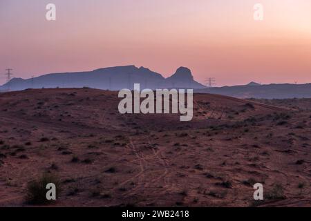 Vista mozzafiato dell'alba dell'ora d'oro dal deserto di Dubai Maleha con enormi montagne sullo sfondo. Foto Stock