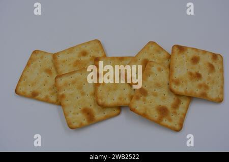 Biscotti di marca, fatti in fabbrica, grossi cracker salati sono disposti su uno sfondo bianco. Foto Stock