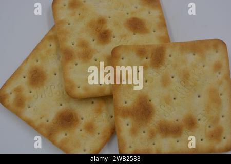 Biscotti di marca, fatti in fabbrica, grossi cracker salati sono disposti su uno sfondo bianco. Foto Stock