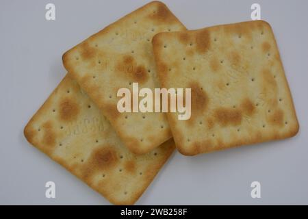 Biscotti di marca, fatti in fabbrica, grossi cracker salati sono disposti su uno sfondo bianco. Foto Stock