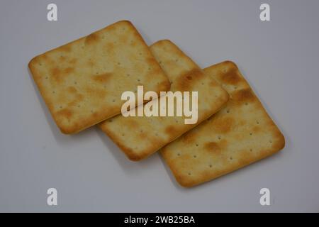 Biscotti di marca, fatti in fabbrica, grossi cracker salati sono disposti su uno sfondo bianco. Foto Stock