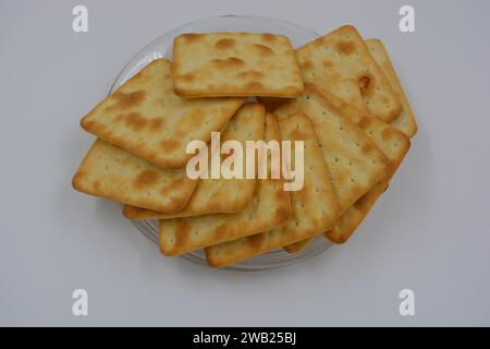 Biscotti di marca, fatti in fabbrica, grossi cracker salati sono disposti su uno sfondo bianco. Foto Stock