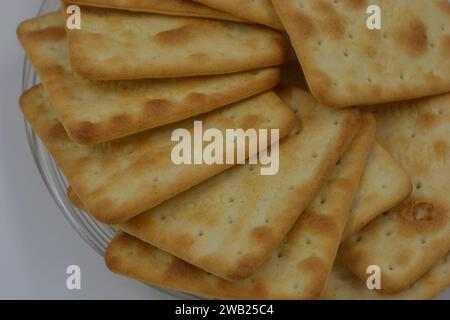 Biscotti di marca, fatti in fabbrica, grossi cracker salati sono disposti su uno sfondo bianco. Foto Stock