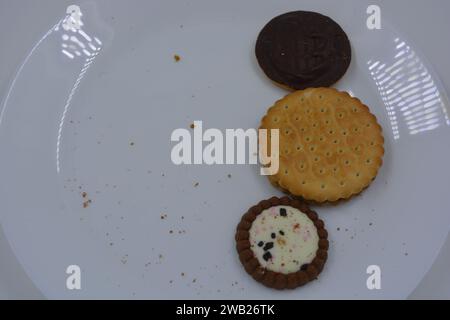 Biscotti di marca di vari tipi sono disposti in un piatto di vetro bianco. Foto Stock