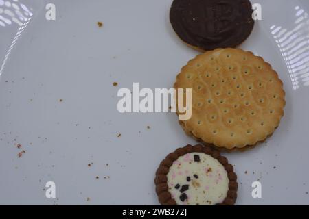 Biscotti di marca di vari tipi sono disposti in un piatto di vetro bianco. Foto Stock