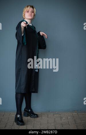 Una donna bionda caucasica vestita da mago con una bacchetta magica Foto Stock