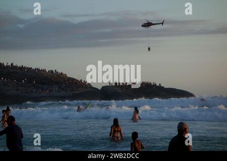 Rio de Janeiro, Rio de Janeiro, Brasile. 7 gennaio 2024. Il Rio de Janeiro Air Sea Rescue ha eseguito con successo un'operazione di salvataggio al tramonto sulla spiaggia di Ipanema, salvando un nuotatore in difficoltà. Sullo sfondo delle pietre di Arpoador, un elicottero ha portato l'individuo salvato davanti a centinaia di persone che si riuniscono ogni giorno per assistere agli splendidi tramonti. Questo incidente ha sottolineato l'intensa attività nelle acque di Rio dall'inizio del nuovo anno, con un notevole aumento delle operazioni di salvataggio che rispondono alle condizioni di surf. (Immagine di credito: © Bob Karp/ZUMA Press Wire) SOLO USO EDITORIALE! Foto Stock