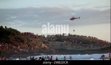 Rio de Janeiro, Rio de Janeiro, Brasile. 7 gennaio 2024. Il Rio de Janeiro Air Sea Rescue ha eseguito con successo un'operazione di salvataggio al tramonto sulla spiaggia di Ipanema, salvando un nuotatore in difficoltà. Sullo sfondo delle pietre di Arpoador, un elicottero ha portato l'individuo salvato davanti a centinaia di persone che si riuniscono ogni giorno per assistere agli splendidi tramonti. Questo incidente ha sottolineato l'intensa attività nelle acque di Rio dall'inizio del nuovo anno, con un notevole aumento delle operazioni di salvataggio che rispondono alle condizioni di surf. (Immagine di credito: © Bob Karp/ZUMA Press Wire) SOLO USO EDITORIALE! Foto Stock