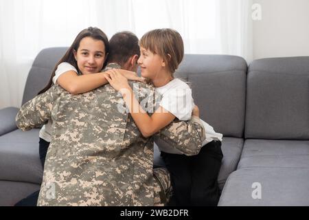 padre militare e due figlie a casa Foto Stock