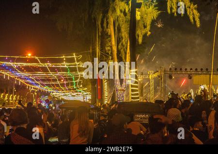 I fuochi d'artificio vengono girati da un concerto a mezzanotte sulla riva del fiume / Capodanno 2023 - 2024. Kampot, Cambogia. © Kraig Lieb Foto Stock